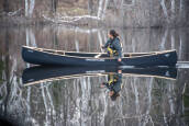 Nova Craft Prospector 15 Blue Steel with Ash trim being paddled as a solo canoe from the bow seat